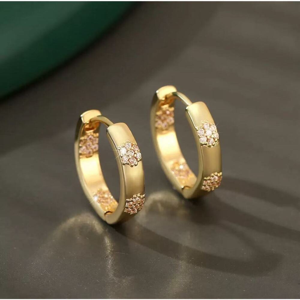 Angular U-frame earrings with repeated hollow cutouts.